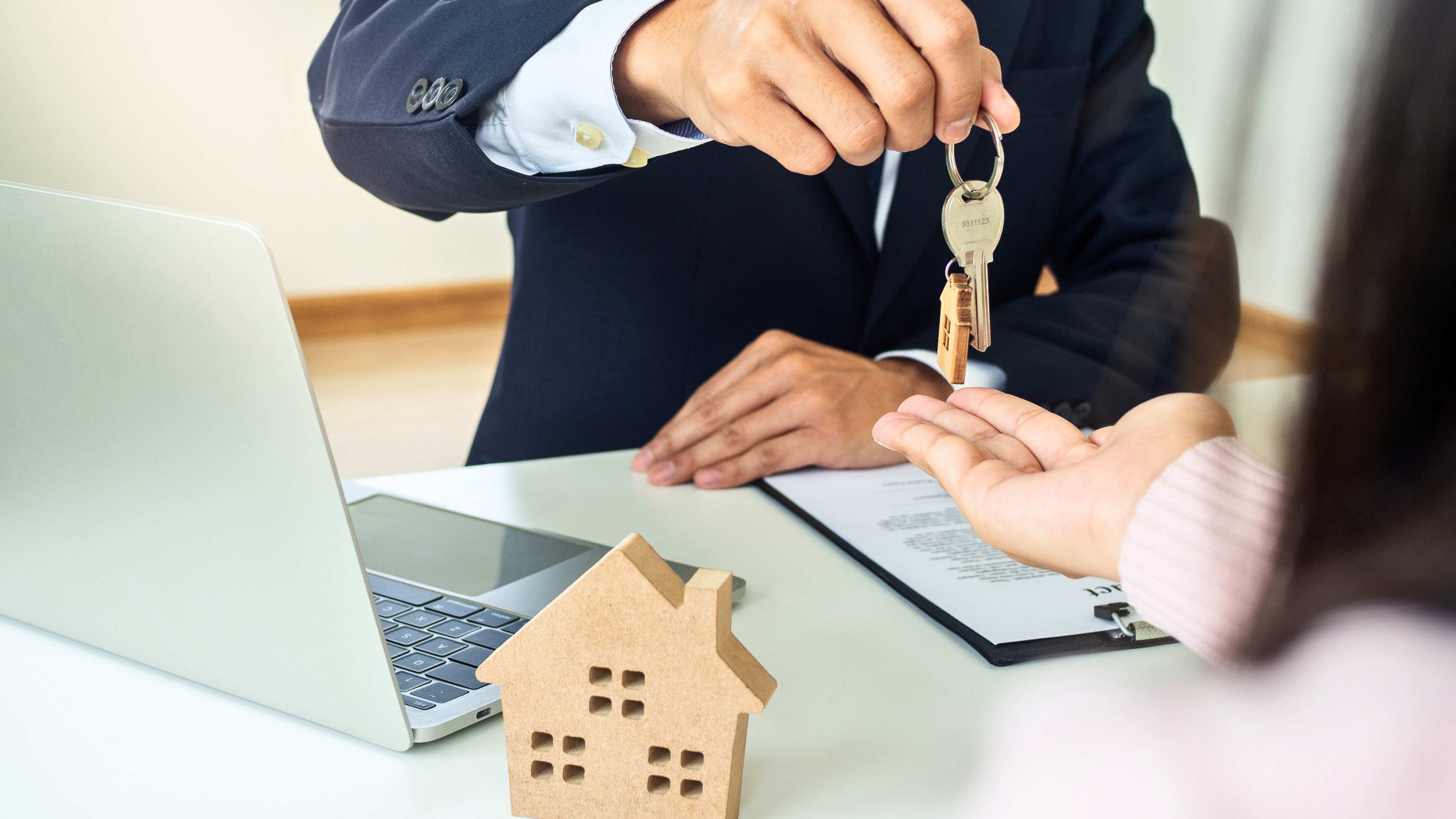 One person handing over house keys to another