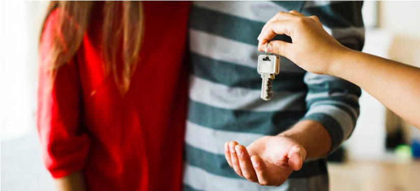 One person handing over house keys to another