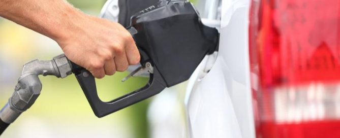 A hand pumping gas into a vehicle