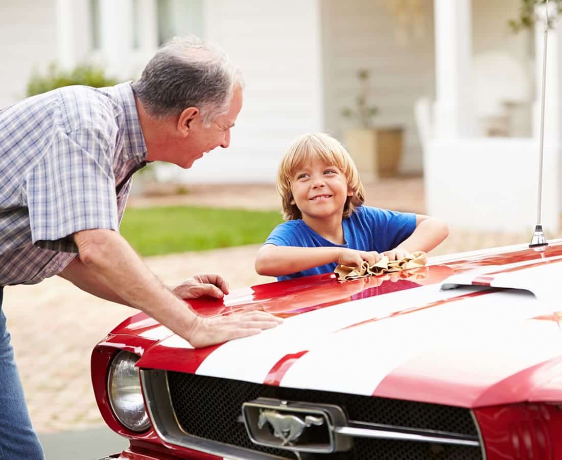 A day and his son cleaning a Mustang car.