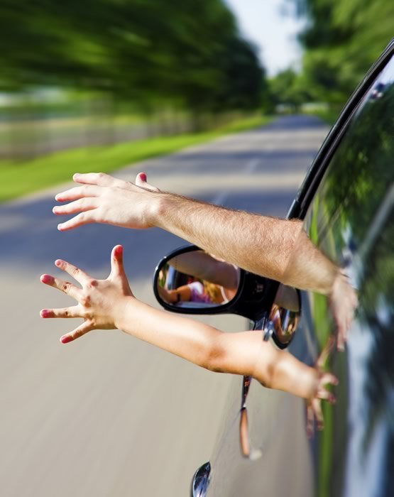 Two hands sticking out the window of a car window