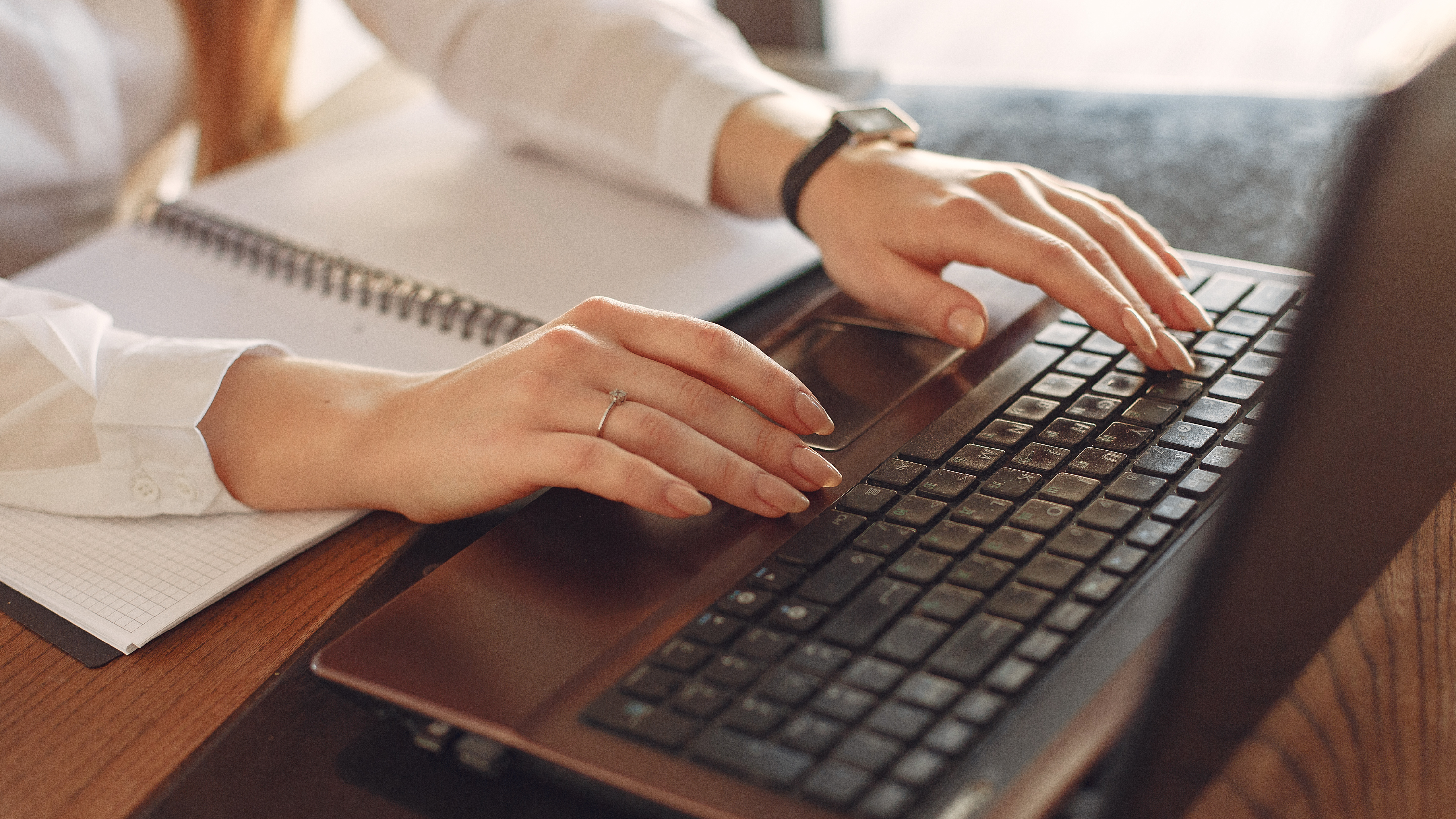 A woman's hands typing on a keyboard