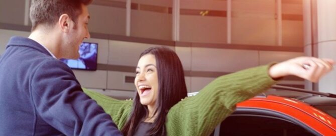excited couple at a car dealership